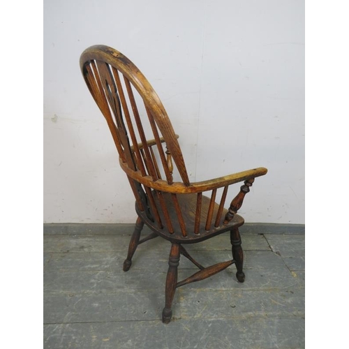 751 - A 19th Century elm hoop-back Windsor chair, having shaped and pierced splat, on turned supports with... 