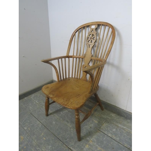 752 - A 19th Century pale elm Windsor wheelback chair, on canted supports with a turned 'H' stretcher.  H9... 