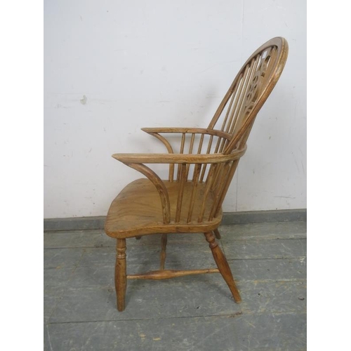 752 - A 19th Century pale elm Windsor wheelback chair, on canted supports with a turned 'H' stretcher.  H9... 