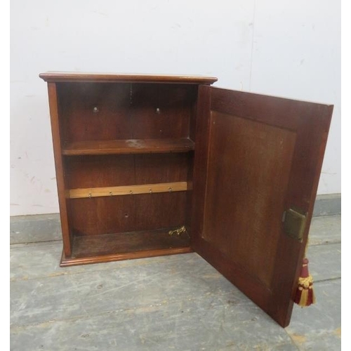 757 - A late Victorian mahogany wall-hanging key cupboard, the panelled door opening onto a fitted shelf a... 