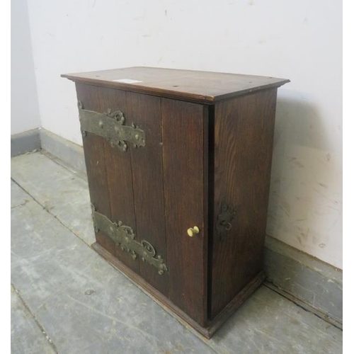 758 - An Arts and Crafts period oak tabletop cabinet, having ornately shaped hinges and lock escutcheon, t... 