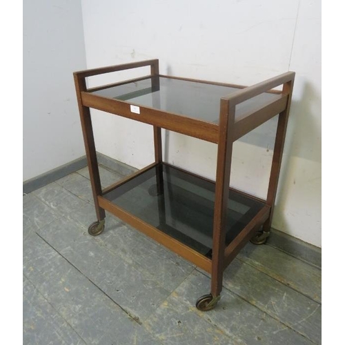 760 - A mid-century afromosia teak two-tier drinks trolley, having loose smoked glass shelves, on square s... 