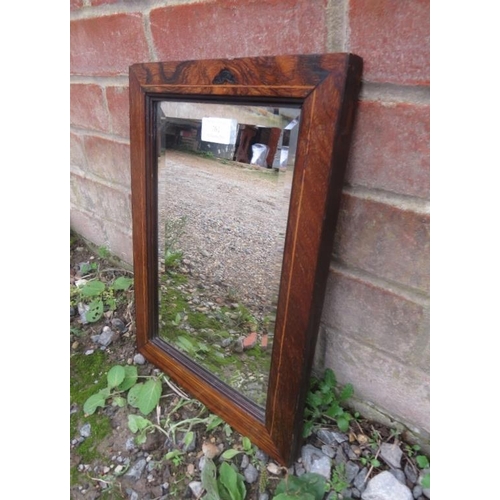 761 - A 19th Century bevelled shaving mirror, within a rosewood surround strung with boxwood.  H37cm W27cm... 