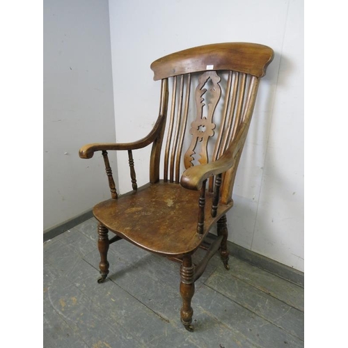 791 - A 19th century elm and beech Windsor chair of large proportions, the carved and pierced backsplat wi... 