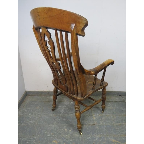 791 - A 19th century elm and beech Windsor chair of large proportions, the carved and pierced backsplat wi... 