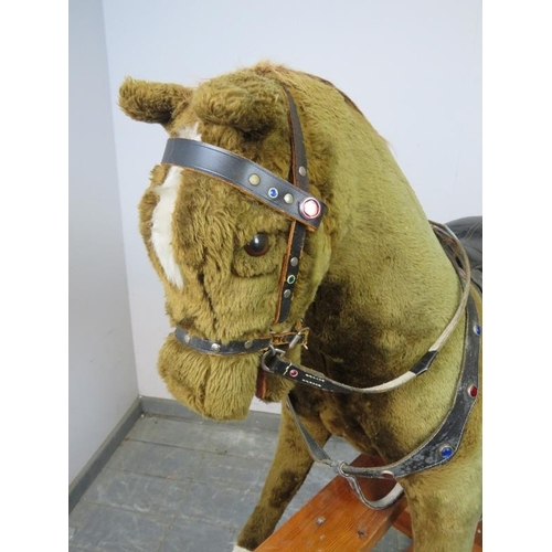 797 - A vintage 48” rocking horse by Pegasus toys, covered in brown fur and with real leather saddle and g... 