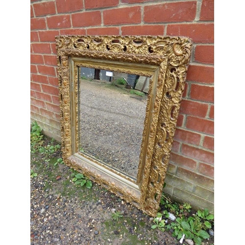 802 - A 19th century wall mirror within a very ornate pierced gilt gesso frame modelled as shells and acan... 