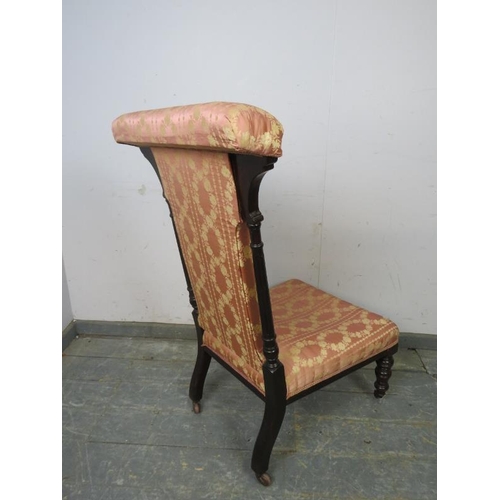 807 - A late Victorian ebonised prix dieux, having reeded uprights and upholstered in pink damask material... 