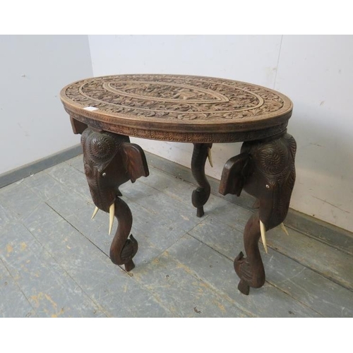 810 - An antique hardwood Anglo Indian elephant table, the oval top relief carved with foliate borders and... 