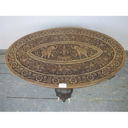 810 - An antique hardwood Anglo Indian elephant table, the oval top relief carved with foliate borders and... 