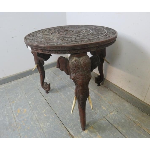 811 - An antique padouk elephant table, the circular top relief carved with foliate borders and central pa... 