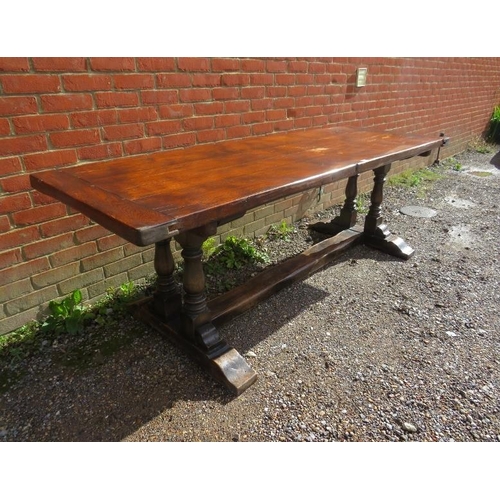 816 - A vintage medium oak refectory table, on twin baluster end supports and rail feet with a middle stre... 