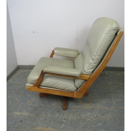 818 - A mid-century swivel lounge chair, the teak frame with mushroom leather upholstery, on splayed suppo... 