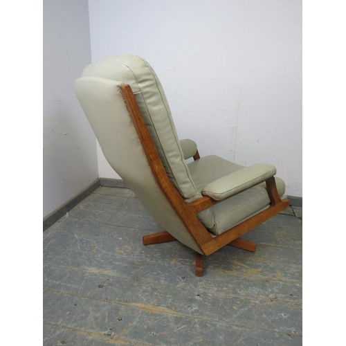 818 - A mid-century swivel lounge chair, the teak frame with mushroom leather upholstery, on splayed suppo... 