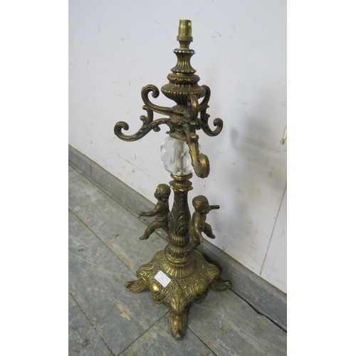 830 - A vintage gilt metal table lamp in the Rococo taste, having faceted glass and cherub decoration, on ... 