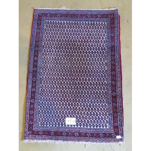 860 - A mid 20th Century Persian rug with repeat central block pattern. Cream on red. 145cm x 100cm.
Condi... 