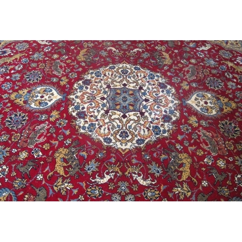 867 - A 20th Century Indian wool carpet with a central medallion and animals amongst foliage.  310cm x 200... 