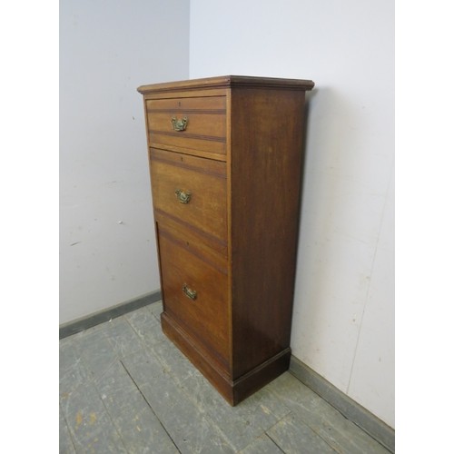 770A - A late Victorian mahogany cabinet of narrow proportions, housing three graduated drawers with presse... 