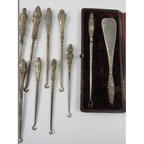 376 - A collection of silver mounted long button hooks of various design including two cased examples. All... 