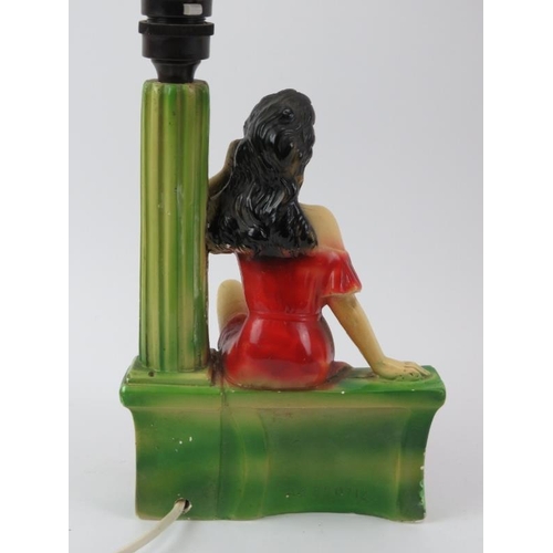 173 - A vintage cast plaster table lamp, circa 1950s. Modelled with a female in a long red dress on the te... 