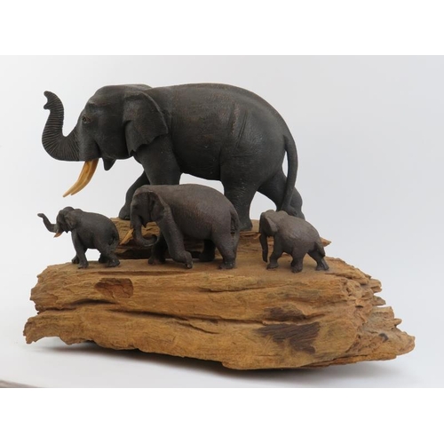 175 - A large vintage African carved wood elephant display, 20th century. The carved and painted elephants... 