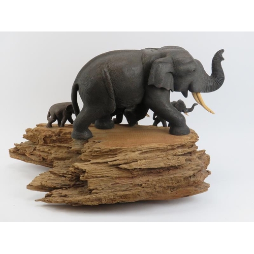 175 - A large vintage African carved wood elephant display, 20th century. The carved and painted elephants... 