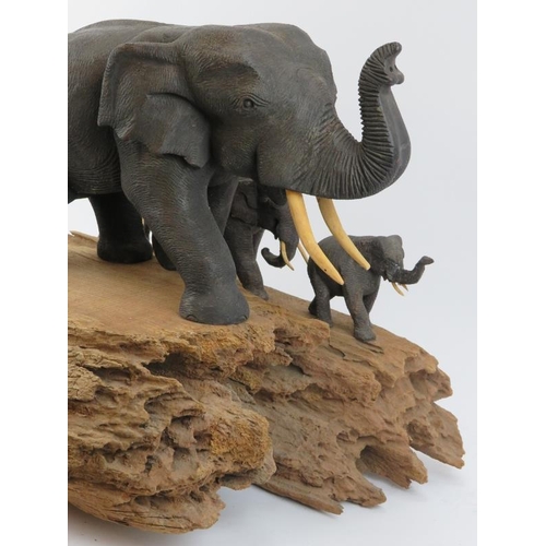 175 - A large vintage African carved wood elephant display, 20th century. The carved and painted elephants... 