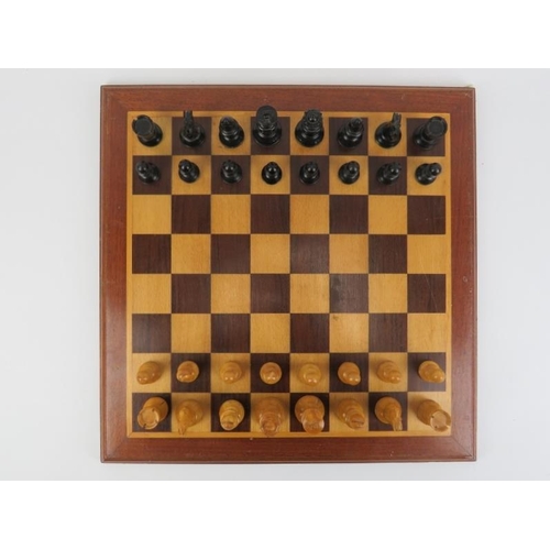 23 - An ebonised wood and sycamore chess set and parquetry inlaid gaming board.
The chess piece bases wei... 