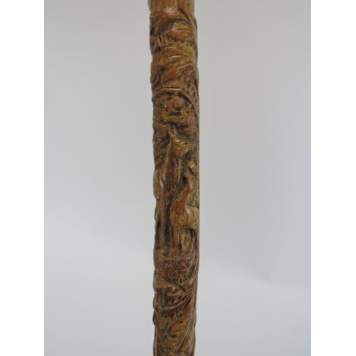 86 - An antique wooden walking cane with decoration carved in relief, probably 19th century. The handle s... 