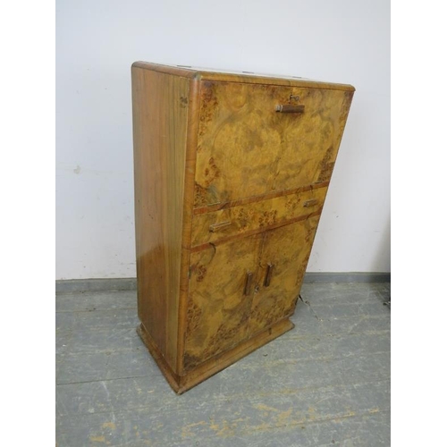 716 - An Art Deco Period burr walnut cocktail cabinet, the fall front and rising top opening to reveal a f... 