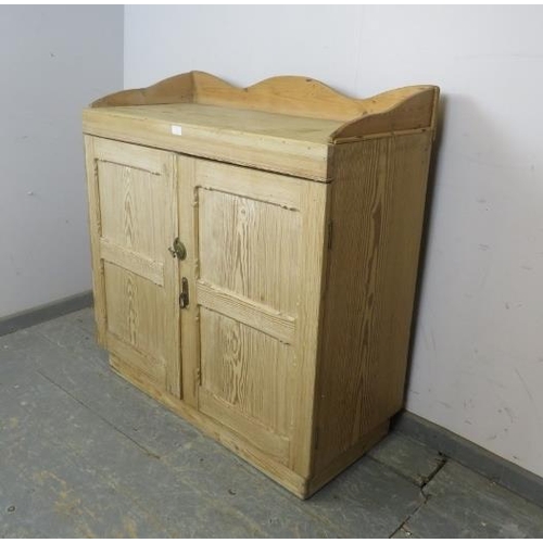 726 - An antique Continental pitch pine side cabinet, the shaped ¾ gallery above panelled doors opening on... 