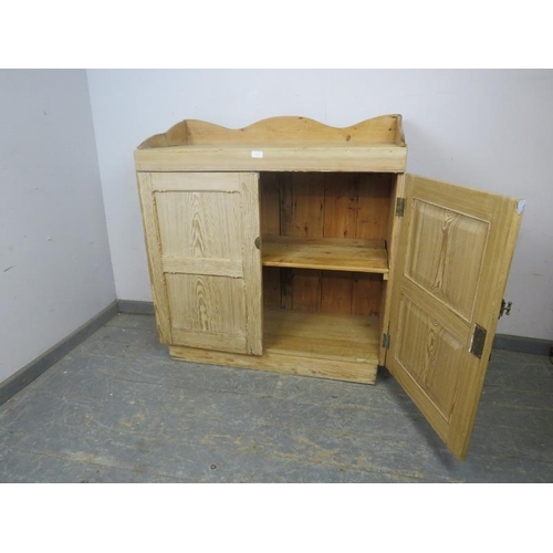 726 - An antique Continental pitch pine side cabinet, the shaped ¾ gallery above panelled doors opening on... 