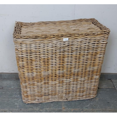 727 - An antique woven willow laundry basket, of unusually tall and narrow proportions, the hinged lid ope... 