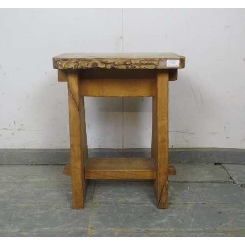 730 - A vintage primitive light oak stool, the top with live edge, on a peg-jointed base with pie-crust de... 