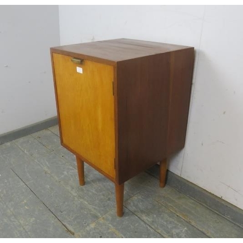 731 - A well-constructed mid-century solid teak side cabinet, the door with brass handle opening onto a lo... 