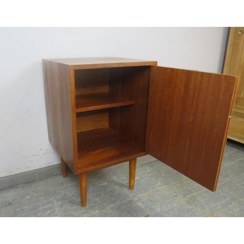 731 - A well-constructed mid-century solid teak side cabinet, the door with brass handle opening onto a lo... 