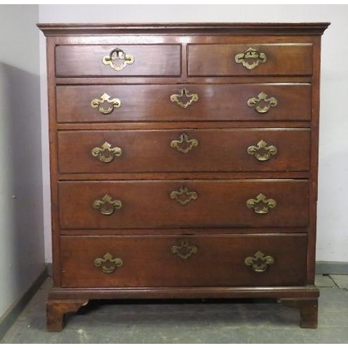 743 - An 18th century oak chest, housing two short and four long graduated drawers with pierced brass hand... 