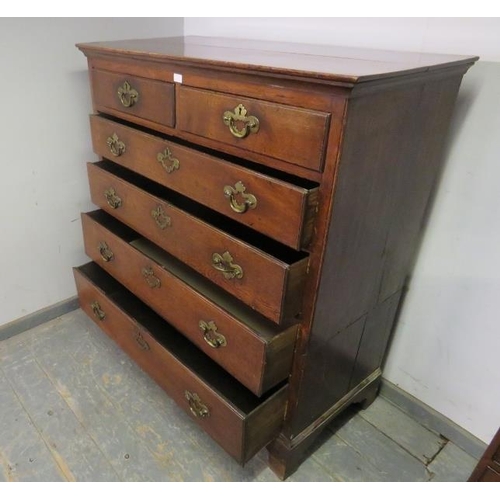 743 - An 18th century oak chest, housing two short and four long graduated drawers with pierced brass hand... 