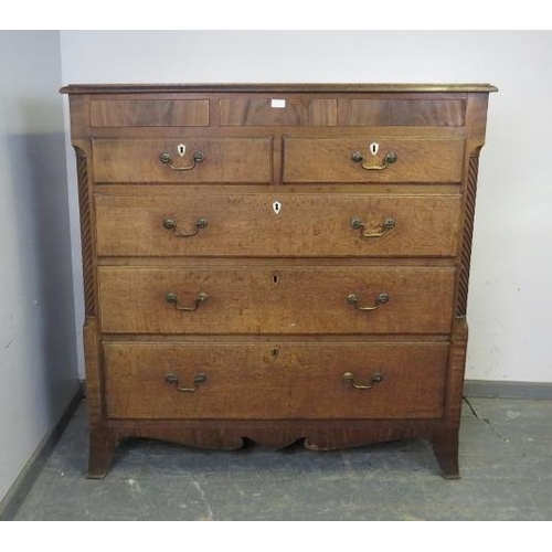 744 - A large George III oak chest, housing three blind drawers above two short and three long graduated d... 