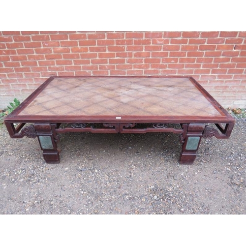 751 - A large antique Chinese bed, converted into a statement coffee table, the rattan top above a carved ... 