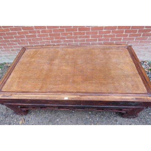 752 - A large antique Chinese bed, converted into a statement coffee table, the rattan top above a carved ... 