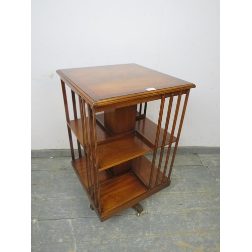 753 - An Edwardian style mahogany revolving bookcase, crossbanded and strung with ebony, on sabre legs wit... 