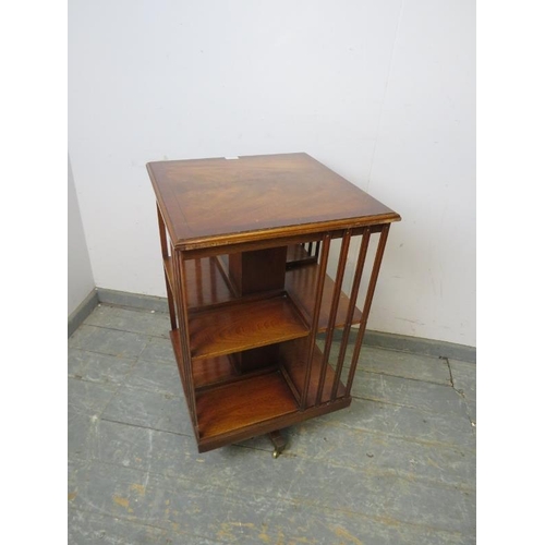 753 - An Edwardian style mahogany revolving bookcase, crossbanded and strung with ebony, on sabre legs wit... 