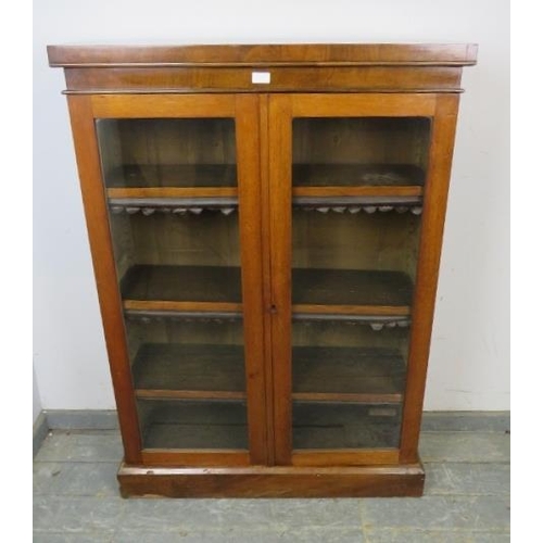 763 - A Victorian mahogany enclosed bookcase, the glazed doors opening onto three height adjustable shelve... 