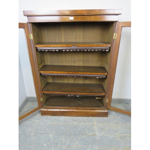 763 - A Victorian mahogany enclosed bookcase, the glazed doors opening onto three height adjustable shelve... 