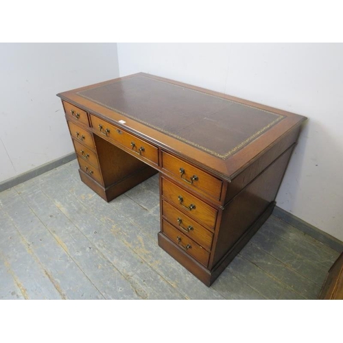 780 - An antique style oak pedestal desk, the top with inset leather writing surface, housing a configurat... 