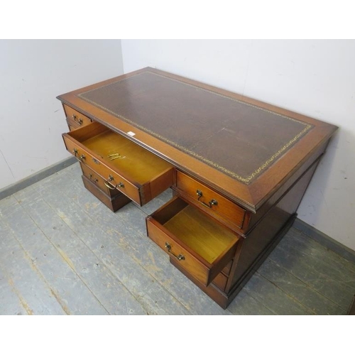 780 - An antique style oak pedestal desk, the top with inset leather writing surface, housing a configurat... 