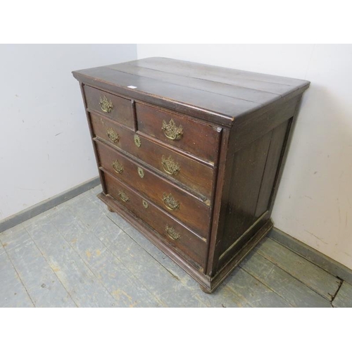 784 - An 18th century oak chest, housing two short and three long graduated drawers with pierced brass han... 