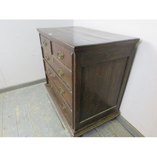 784 - An 18th century oak chest, housing two short and three long graduated drawers with pierced brass han... 