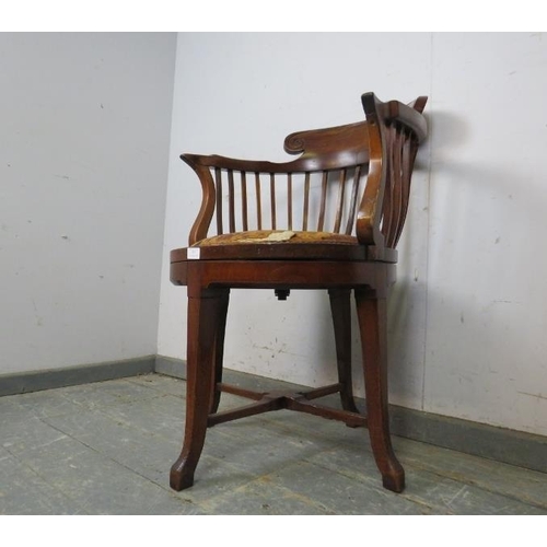 787 - An unusual Edwardian mahogany revolving desk chair, the shaped back above a seat pad upholstered in ... 